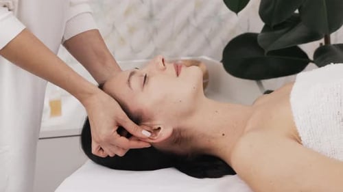 Relaxed Woman Lying on Massage Bed for Massage Spa Treatment