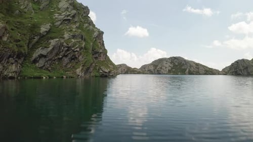 Flying very close above mountain Lake (Lago Grande) in Northern Italy (South Tyrol). Summer clouds a