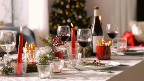 Christmas holiday table setting with candles and wine