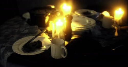 Flickering Candles on Dark Dinner Table Scene