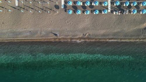 Aerial view of the sea and beach with beach umbrellas and turquoise clear water.
