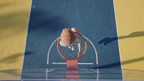 Un homme actif court en sautant haut pour lancer la balle dans le panier