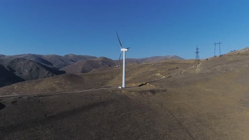 Windturbine dreht sich vor der farbenfrohen Skyline und erzeugt sauberen, erneuerbaren Strom