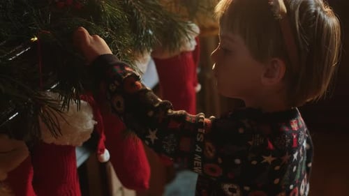 Child Decorating Christmas Tree with Ornaments at Home