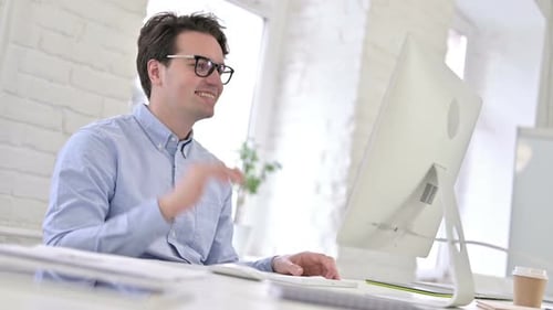 Man Video Conferencing at His Urban Office Desk