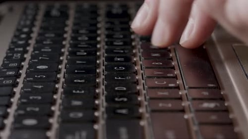Person Putting Information And Words Into Laptop Computer By Typing On Keyboard. - close up