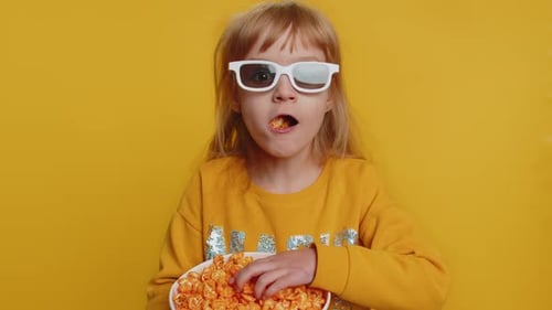 Child with 3D Glasses Eats Popcorn