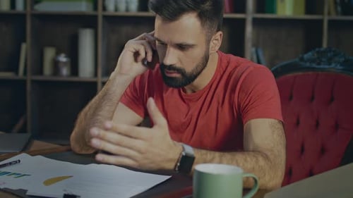 Furious Man Talking on Phone at Desk. Angry Business Man Talking On