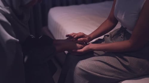 Close Up of Friends Holding Hands on Bed