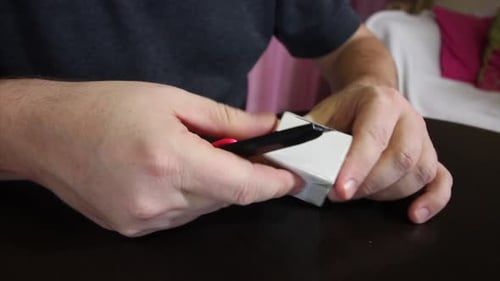 The Man Opens A Cardboard Box With A Knife. Makes A Review Of The Received Parcel.