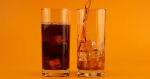 Soda Being Poured in Glass with Ice Cubes