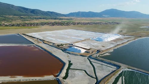 Piles of salt in factory at sunset with salt ponds or salt fields
