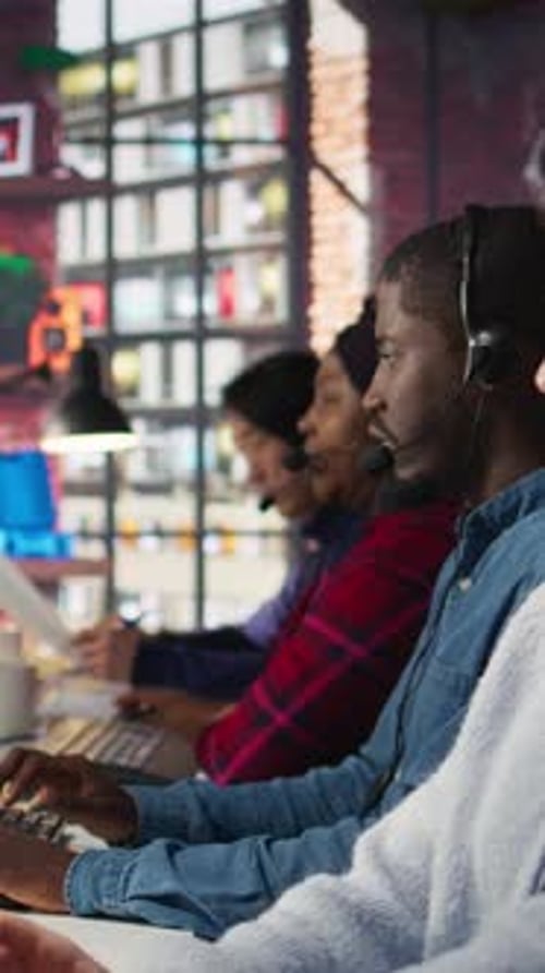 Vertical Video Call Center Staff Members Wearing Headphones Assisting Customers in Office