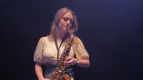 Woman Plays Saxophone with Dark Background