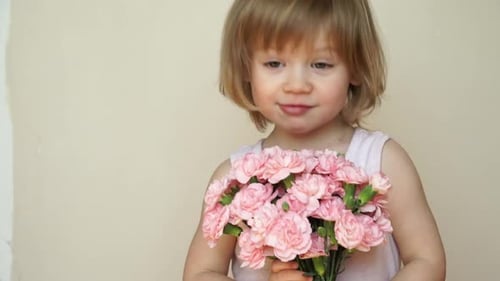 Smiling Child Holding a Pink Flower Bouquet