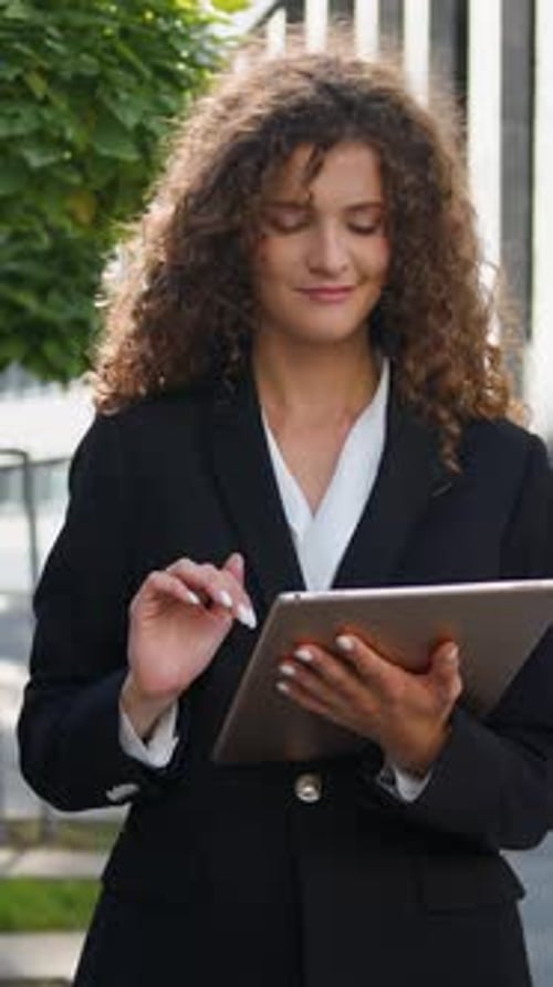 Mujer de negocios caucásica que usa una tableta digital mirando a la cámara que muestra una invitación