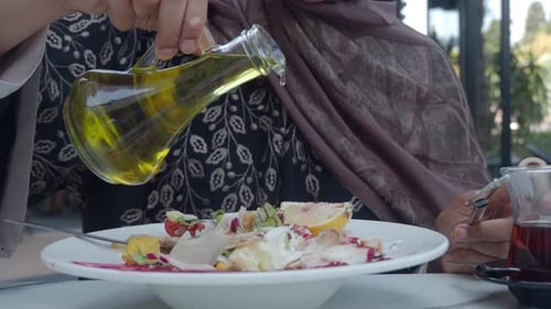 La gente disfruta preparando una ensalada fresca con aceite de oliva e ingredientes frescos