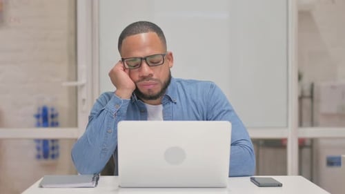 Mixed Race Man schläft während der Arbeit am Laptop