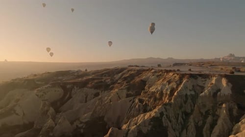 Drone view of hundreds of colorful hot air balloons soaring at sunrise in Cappadocia