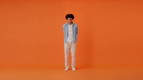 Cheerfull Fellow Looking at Camera and Giving Gift in Studio