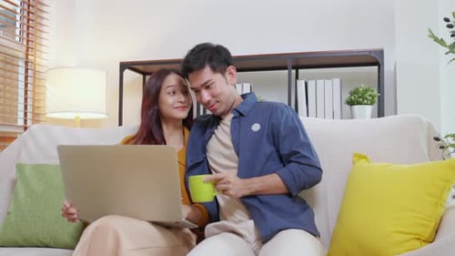 Young Couple Relaxing Together on Couch with Laptop