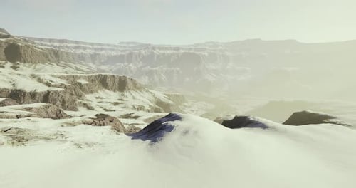 Snowy Mountain Landscape Under Soft Sunlight at Dawn Revealing Rugged Terrain
