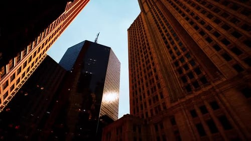 La luz del sol se refleja entre edificios altos en un entorno urbano bullicioso