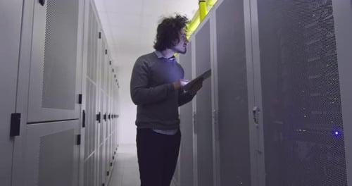Man with Tablet Working in Data Center