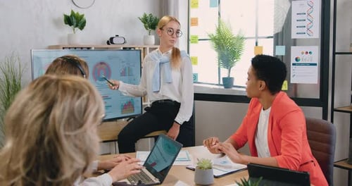 Woman manager holding meeting for business women shows statistical graphs and charts in office
