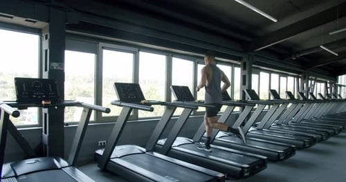 Athletic Man Running on Treadmill at Modern Fitness Club