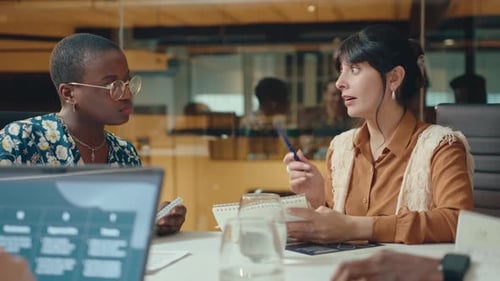 Businesswoman Sharing Ideas with Female Colleague in Office
