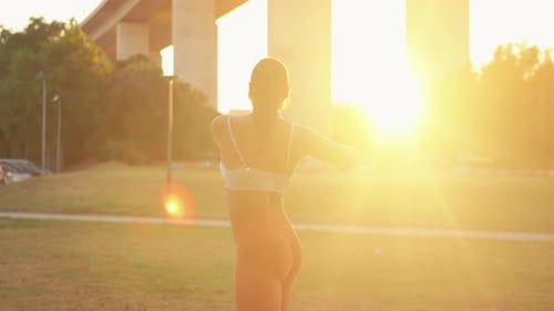 Sporty Woman Doing Stretching Exercises at Park During Sunny Day