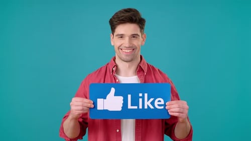 Smiling Man Holds Like Sign and Gives Thumbs Up