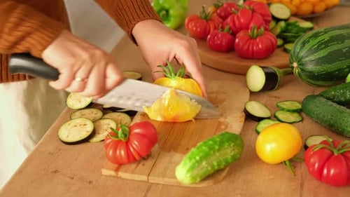 Frau schneidet mit einem Messer frisches rohes Gemüse, Tomaten, Gurken, die auf einem Holzbrett in Scheiben geschnitten werden