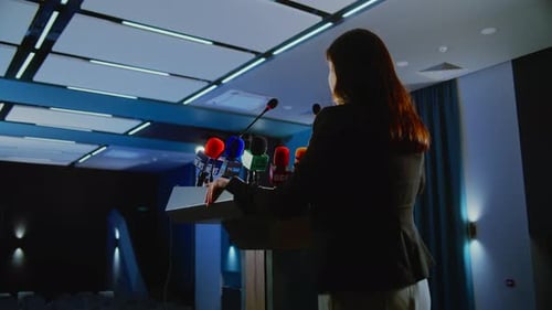 Woman Giving Speech at Press Conference at Podium