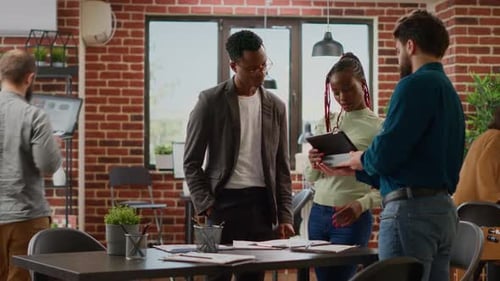 Diverse Group of Coworkers Analyzing Business Charts in Company Office