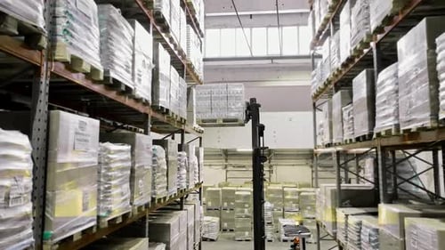 A Forklift Operates in a Spacious Warehouse Moving Pallets Stacked with Goods Highlights the