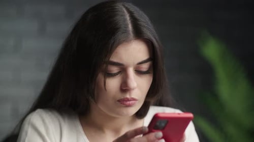 Woman Focused on Smartphone Indoors