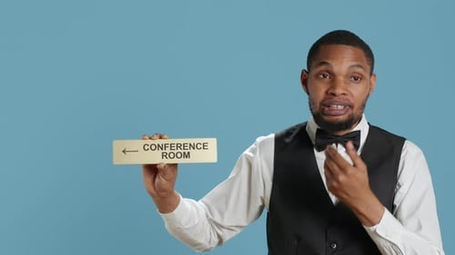 Hotel Concierge Using a Wall Indicator to Guide Clients to the Conference Room