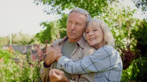 Couple Enjoying a Sunny Day in a Beautiful Garden While Sharing a Tender Moment