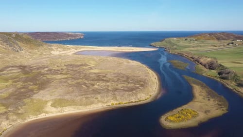 Drohnenfahrt über eine wunderschöne Flussmündung, die ins Meer führt, an der Nordküste Schottlands.