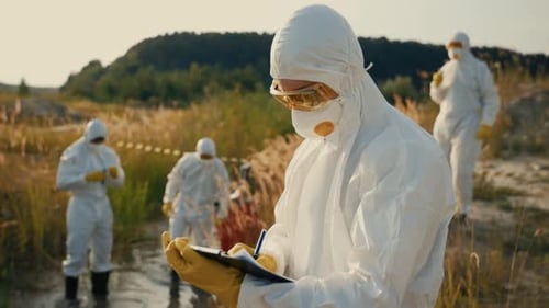 Environmental Scientists Engaged in Field Research While Wearing Protective Gear for Safety