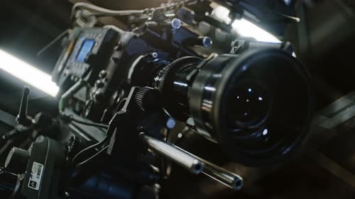 Low angle shot of a professional cinema camera and long telephoto zoom lens, remote device is turnin