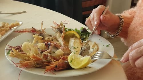 Seafood Meal Being Cut at Restaurant Table