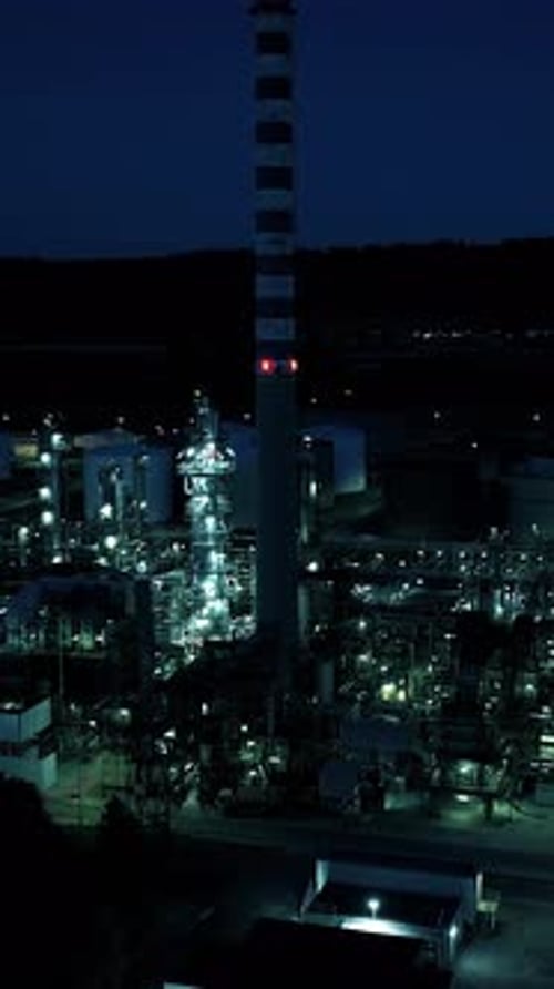Scenic Night View of an Industrial Landscape with Towering Structures and Facilities