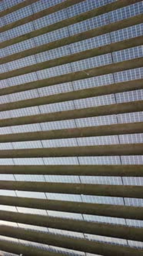 Luftaufnahme von oben auf Sonnenkollektoren Kraftwerk Photovoltaik-Solarmodule bei Sonnenuntergang auf dem Land Von