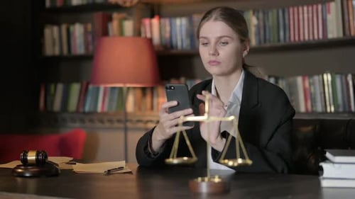 Female Lawyer Using Smartphone in Office
