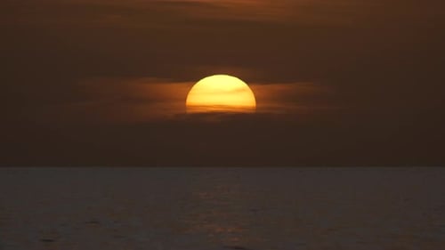 Océano, puesta de sol, gran sol blanco sobre un Dramático fondo de cielo brillante, suave horizonte nocturno sobre el mar oscuro