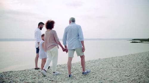 Rear View of Multigeneration Family on a Holiday Walking by the Lake,