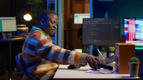 Black Programmer Remotely Working in Home Office Writing Code on Computer